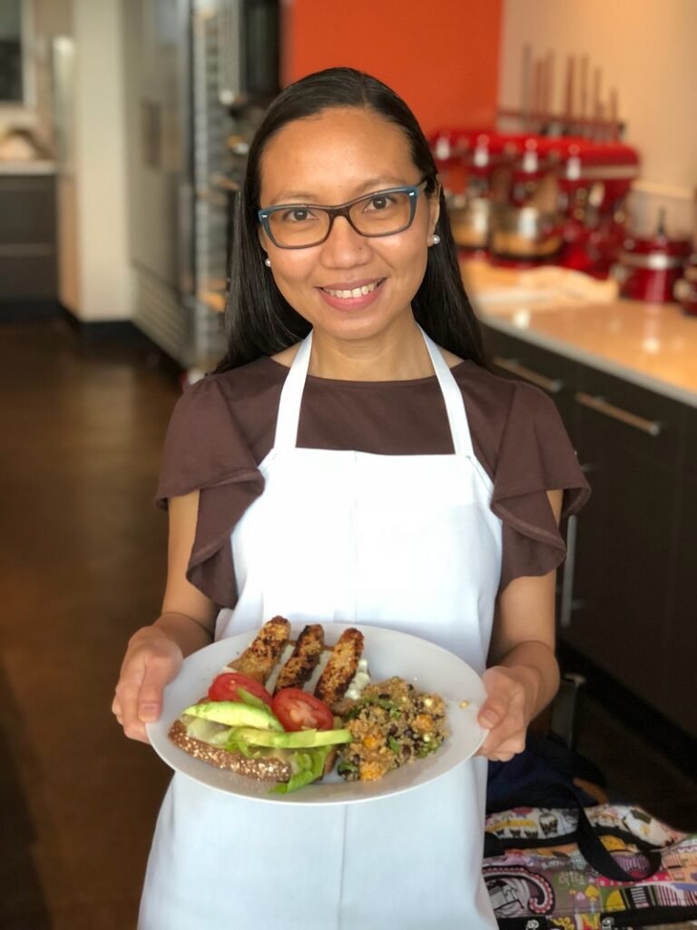 Be Meatless Youtube Channel  - Sally Mae holding a plate of vegan food at Uncorked Kitchen